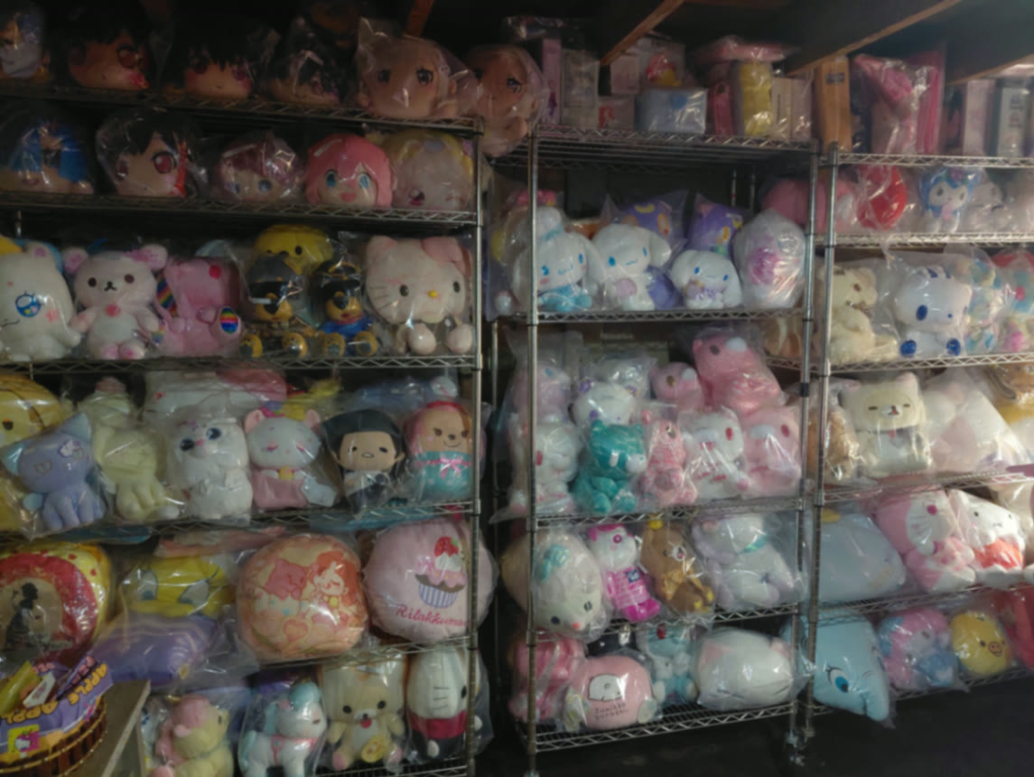 Three chrome shelving units packed floor to ceiling with sealed Sanrio, San-X, and anime plush prizes