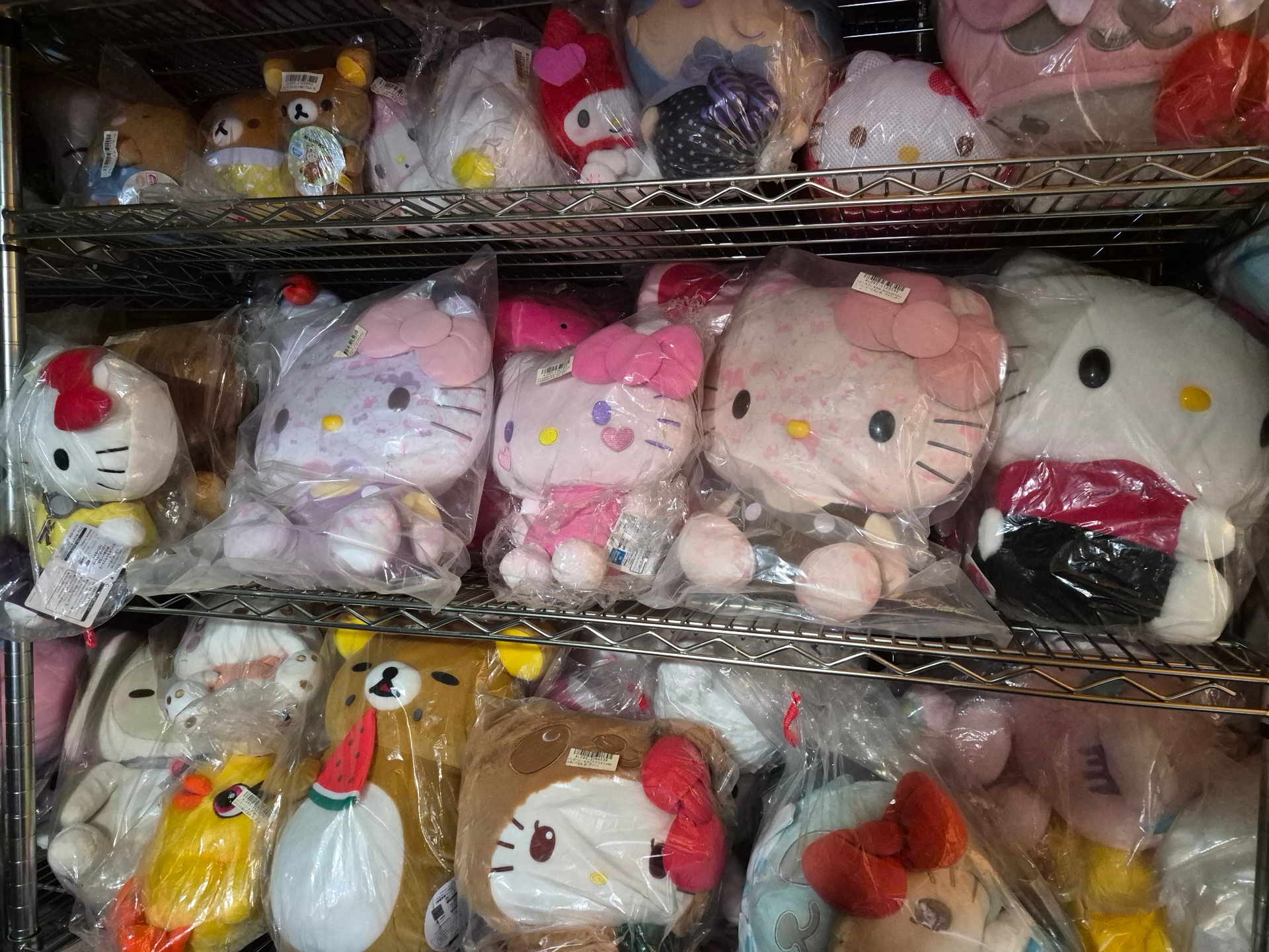 First floor shelves lined with sealed Hello Kitty, Rilakkuma, and My Melody plush prizes