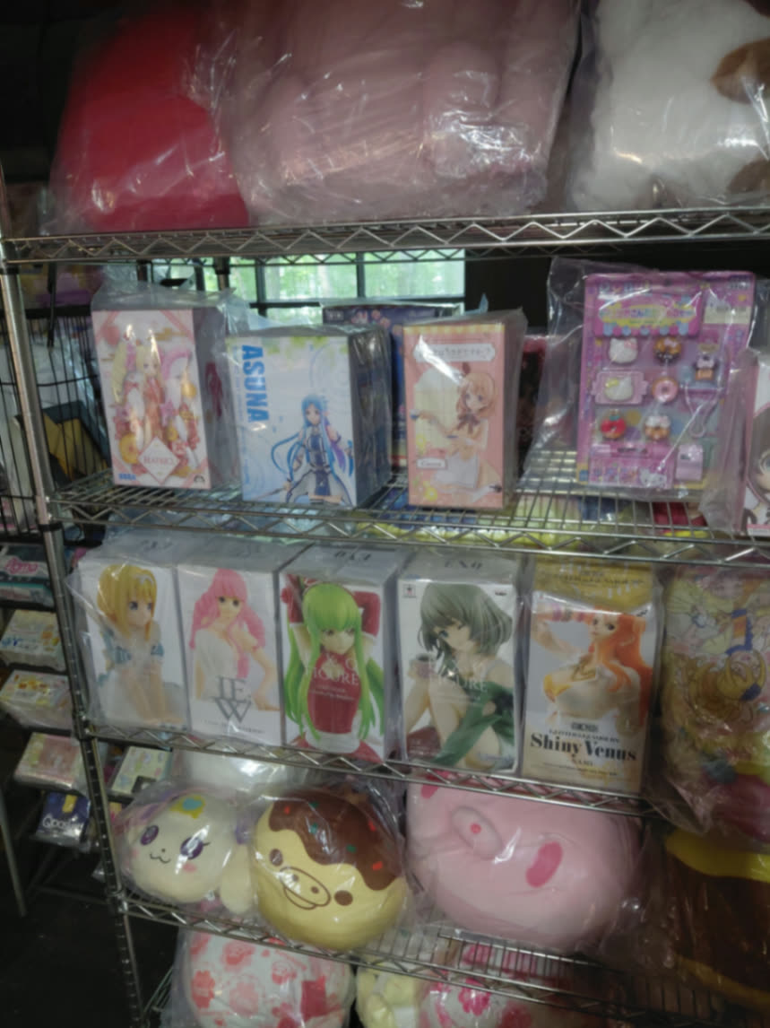 Shelves of boxed Japanese prize figures including Asuna and Q Posket beside sealed plush