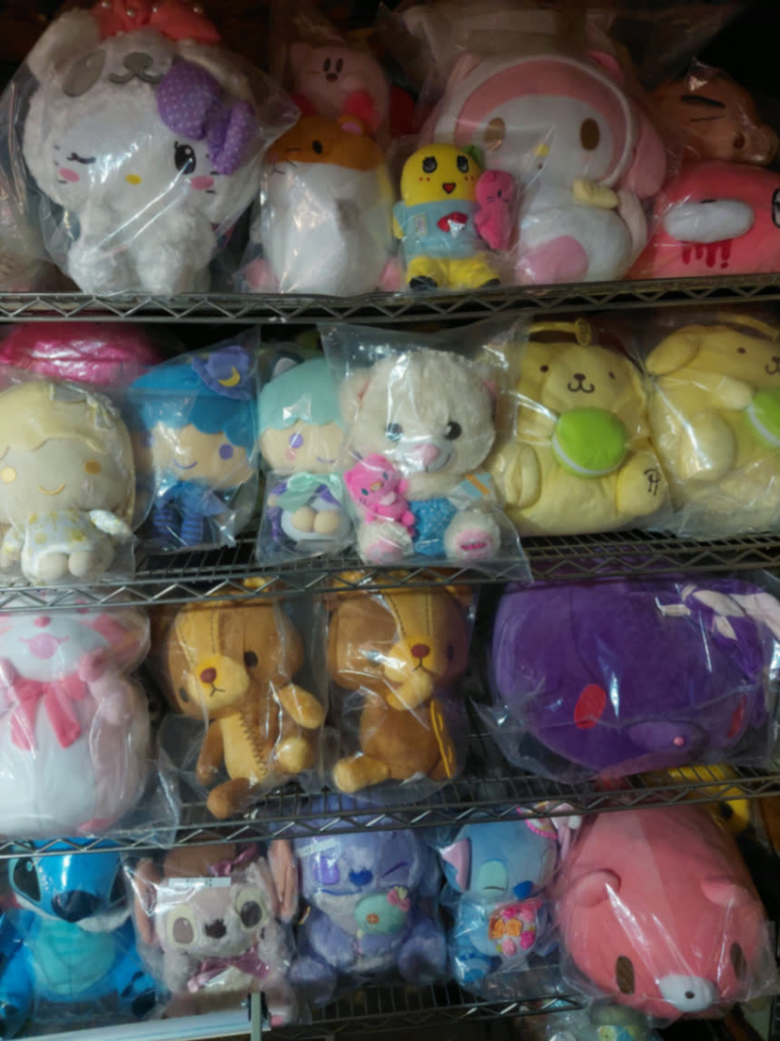 Close rows of sealed plush including Pompompurin, Little Twin Stars, Stitch, and teddy bears